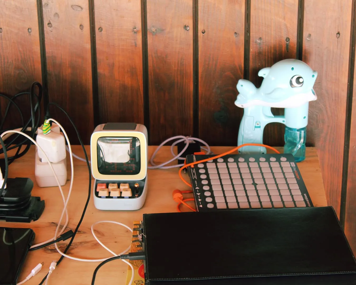 Mesa con mini consola, controlador MIDI y pistola de agua delfín