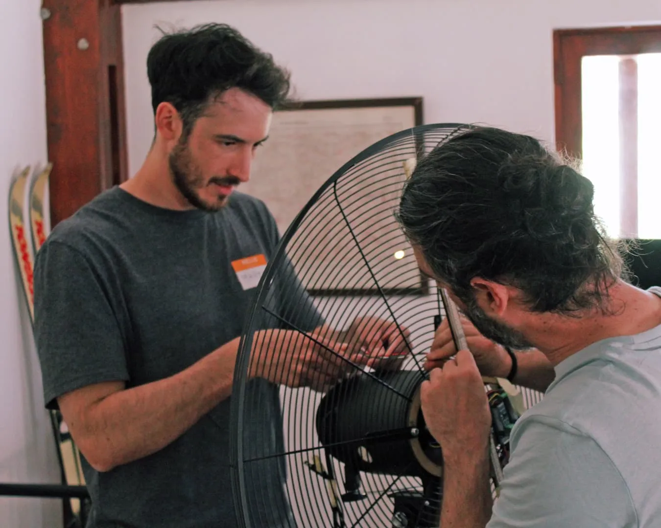 Dos personas montando un juego alt-control sobre un ventilador grande