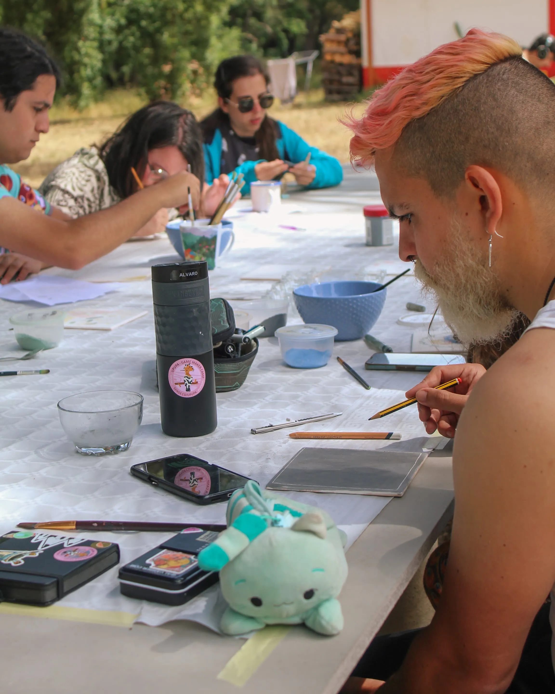Personas dibujando en una mesa al aire libre